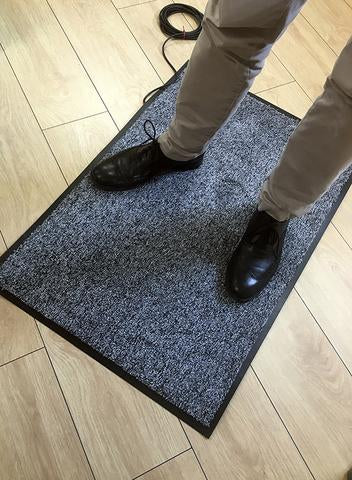 A person standing on a floor pressure mat with shoes on