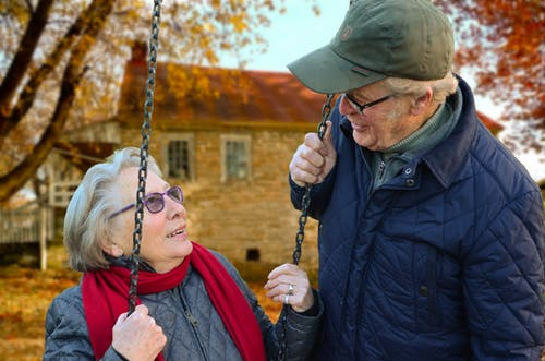 an elderly couple smiling at each other