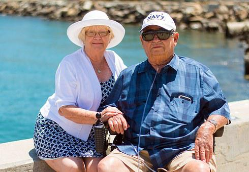 elderly lady holding the hand of her spouse 