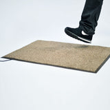 A foot stepping over a barrier mat designed for floor pressure mats