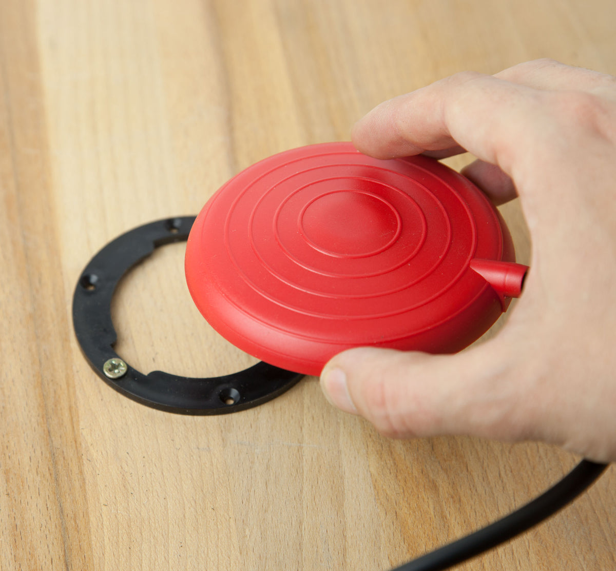 Hand holding red press call button